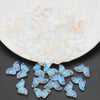 A pile of iridescent, translucent butterfly glass beads for jewelry making.