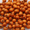 A pile of natural wooden beads in various shades of brown and orange, used for jewelry making and crafts.