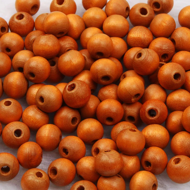 A pile of natural wooden beads in various shades of brown and orange, used for jewelry making and crafts.