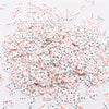 A pile of small polymer clay flower charms in white and red colors for DIY crafts.