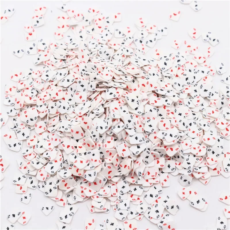 A pile of small polymer clay flower charms in white and red colors for DIY crafts.