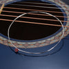 A close-up view of a guitar fretboard showing a string being tested, with a thin wire loop visible.