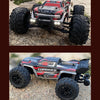 A red and black brushless 4WD monster truck RC car with large tires and LED headlights parked on a rocky surface.
