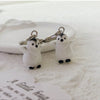 A silver heart keychain set featuring two small white penguin charms.