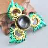 A metal fidget spinner with a rainbow finish, featuring gold and teal accents.