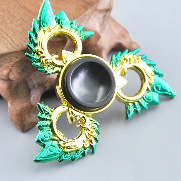 A metal fidget spinner with a rainbow finish, featuring gold and teal accents.