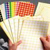 Hands holding a stack of round self-adhesive dot labels in various colors and sizes