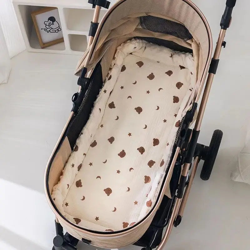 Un matelas en coton doux beige est visible à l'intérieur d'une poussette.