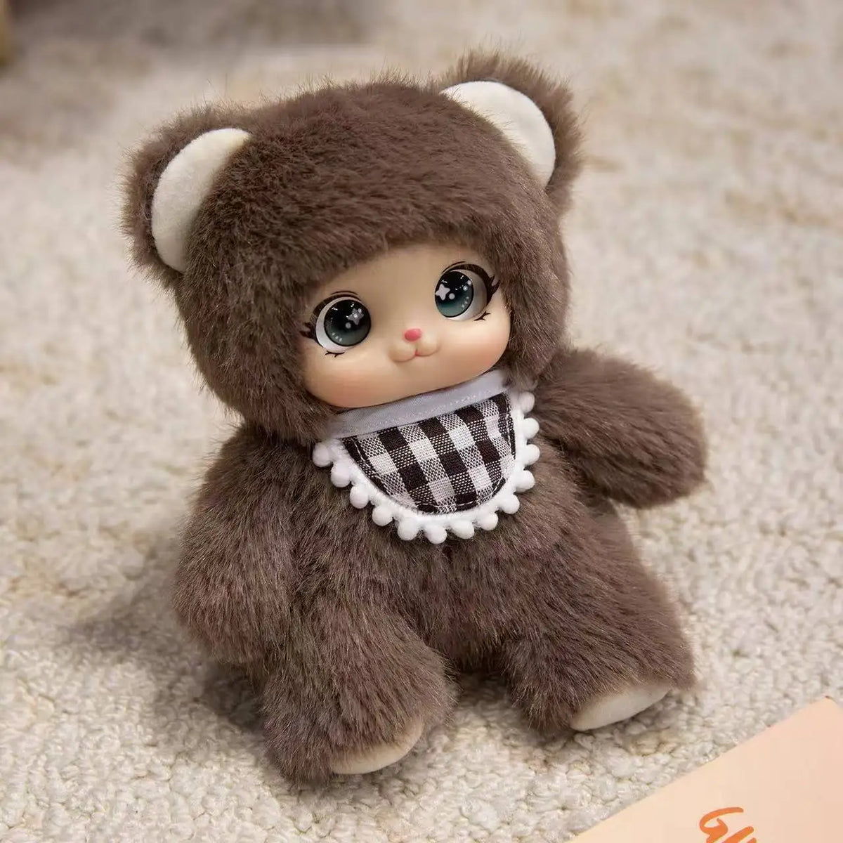 A soft brown plush pendant featuring a bear face with white ears and a checkered collar.
