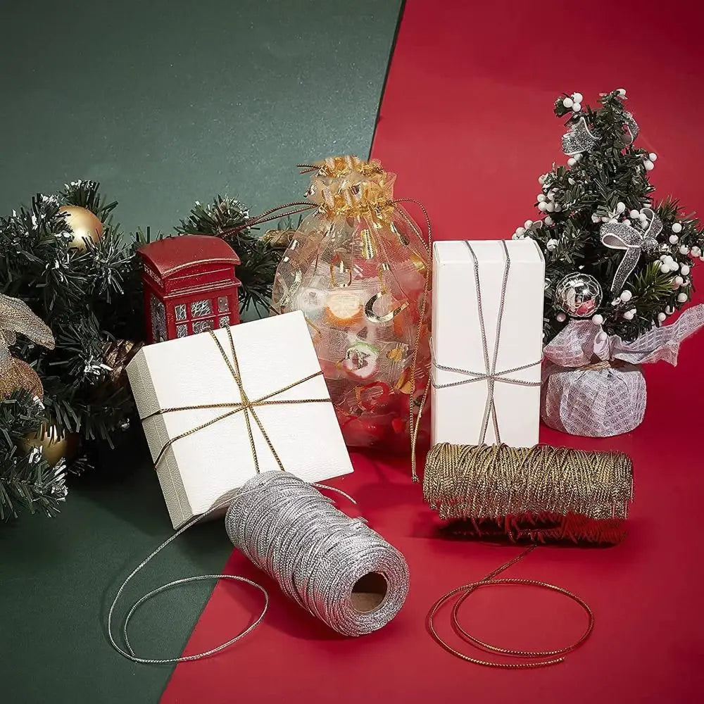 A collection of metallic yarn and glitter thread including a glass jar, a box, and various spools on a red background.