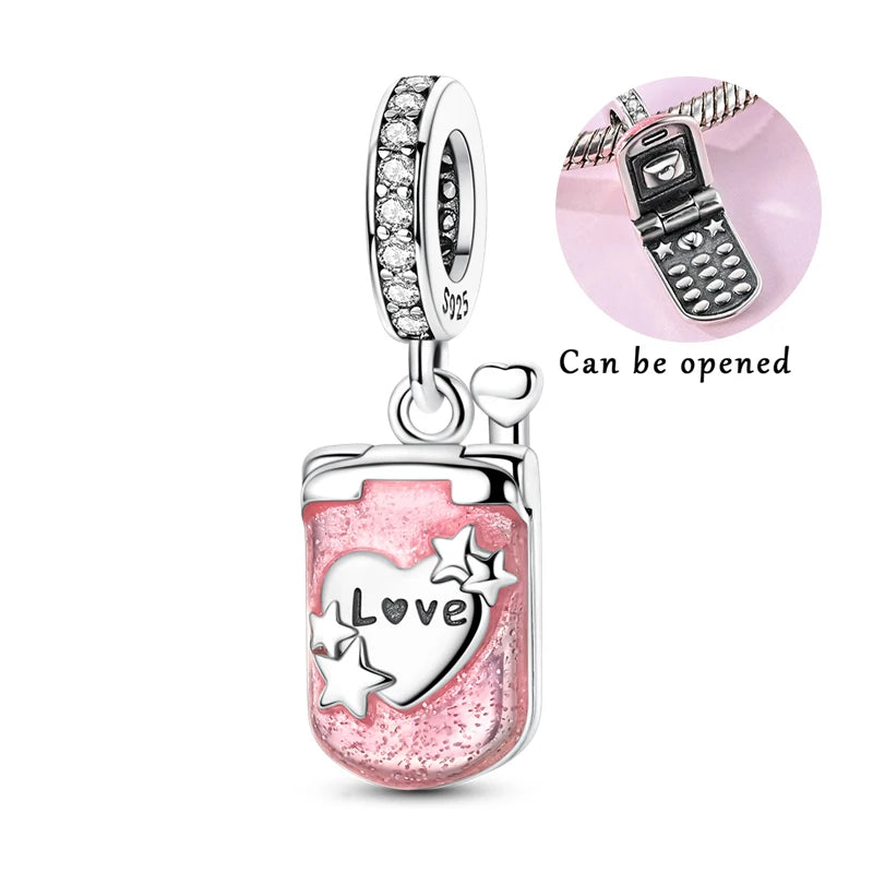 A silver heart charm bead with pink zircon and a vintage cell phone design, showing it can be opened.