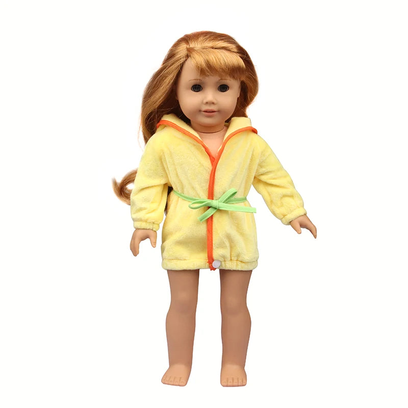 A doll wearing a yellow cartoon animal bathrobe or nightgown set with orange trim and a green tie.