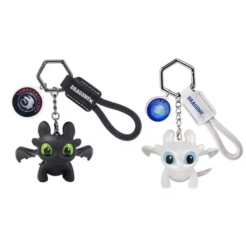 A black dragon keychain featuring a sculpted head with glowing green eyes and movable wings.