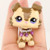A miniature pet animal figure with brown and tan markings and purple bead accessories is held in a hand.