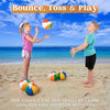 Two boys and a girl playing with colorful inflatable beach balls on a sandy beach.