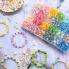 A collection of colorful frosted golden foil acrylic beads and jewelry making supplies arranged on white fabric.