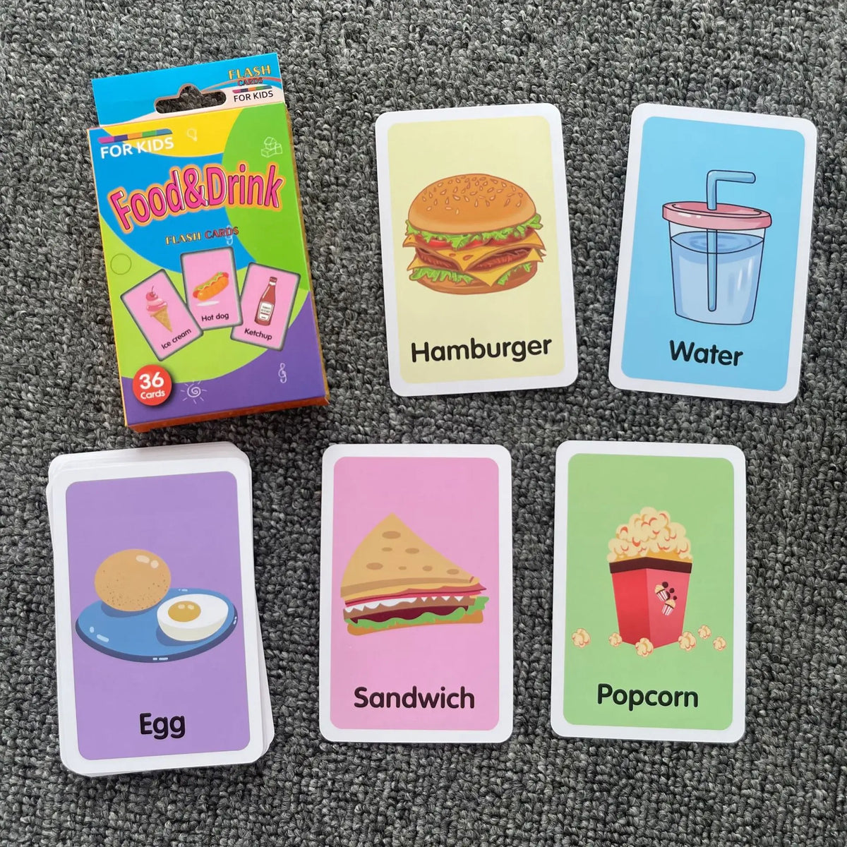 A set of food and drink flash cards for kids featuring images like a hamburger, water, egg, sandwich, and popcorn.