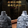 Two handcrafted Aztec death whistles in dark gray and light gray stone are displayed against a dark background.