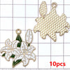 A set of ten gold-toned enamel flower charms, including a large star shape and a lily flower.
