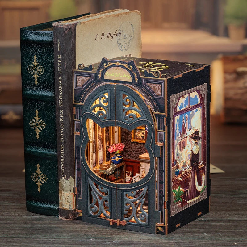 A dark green wooden book nook kit featuring an ornate dollhouse facade with intricate carvings and a small interior scene.