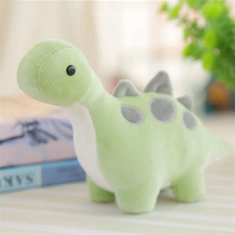 A soft green and white triceratops plush dinosaur toy sitting on a light-colored surface.