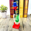 A red and blue bird toy with a long neck stands on a wooden surface next to books.