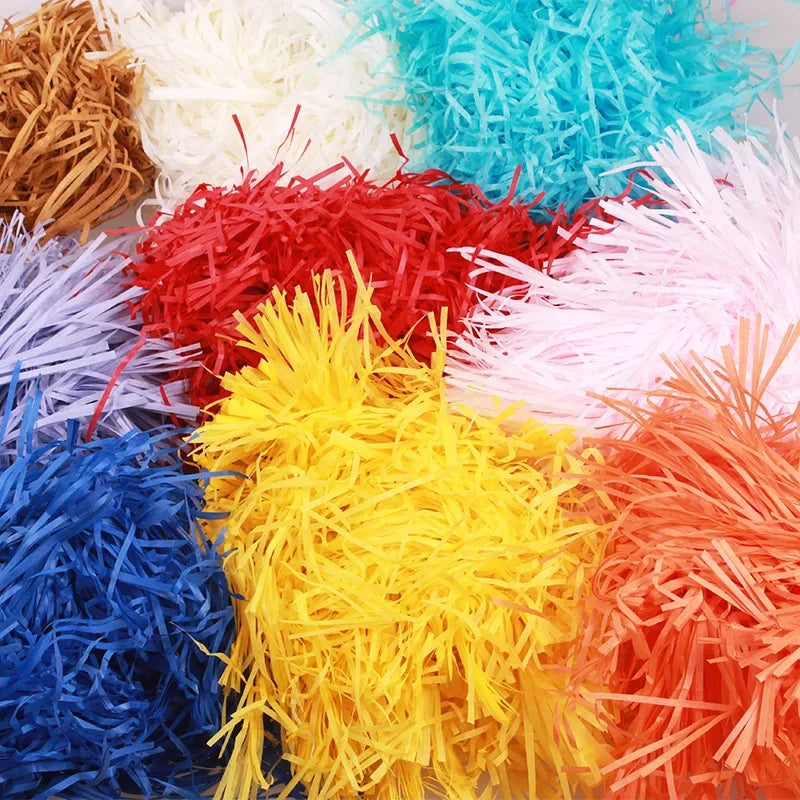 A colorful assortment of raffia paper shreds in red, yellow, blue, white, and orange.