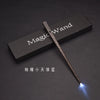 A dark wooden magic wand with an LED light tip rests on a black box, labeled Magic Wand.