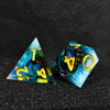 A set of three blue and yellow resin dice shaped like triangles and a dodecahedron for RPG games