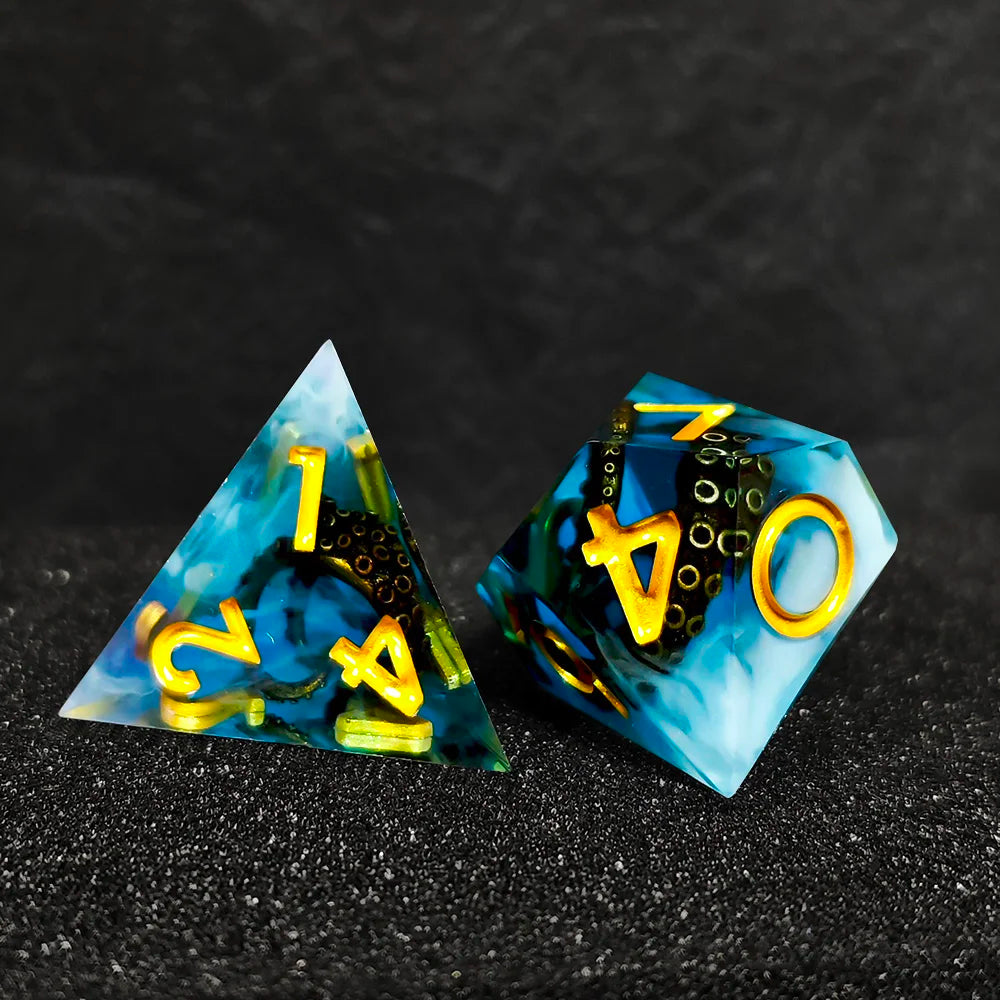 A set of three blue and yellow resin dice shaped like triangles and a dodecahedron for RPG games
