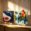 Wall art featuring 3D building blocks shaped like a shark head and a colorful bird, displayed on a wooden easel.