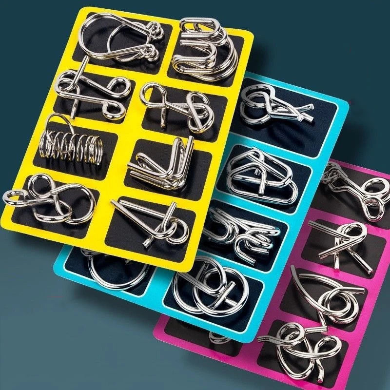 A collection of silver metal wire puzzles and brain teasers arranged in colorful plastic trays.