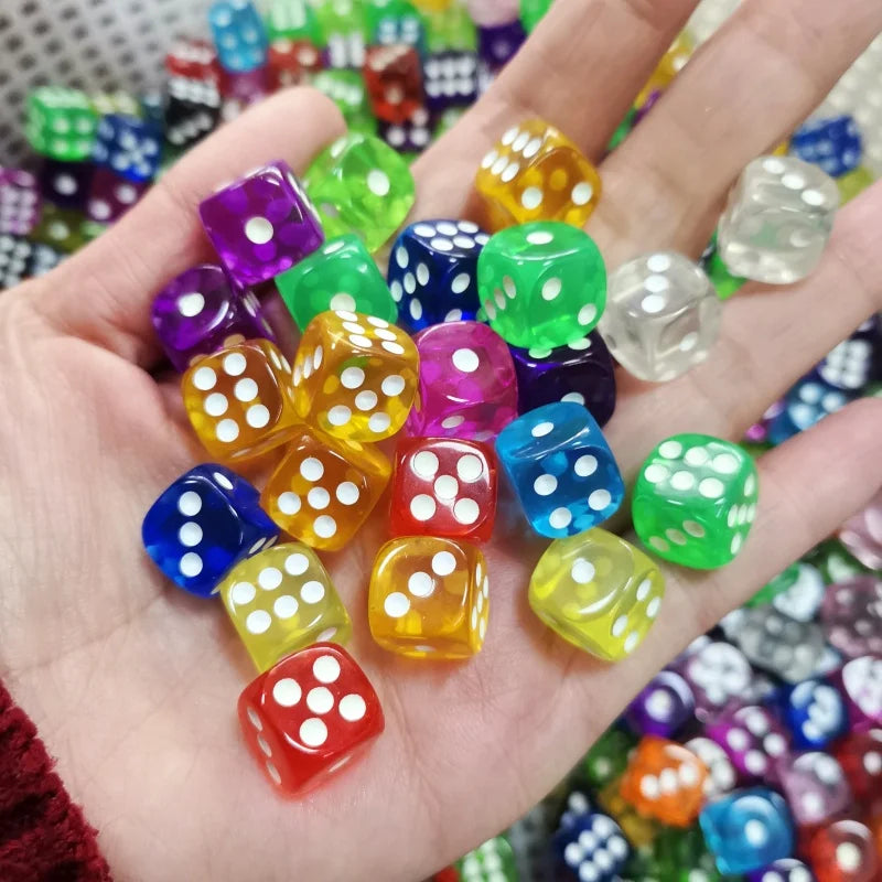 A hand holds a collection of colorful transparent dice in various shades of green, purple, yellow, and blue.