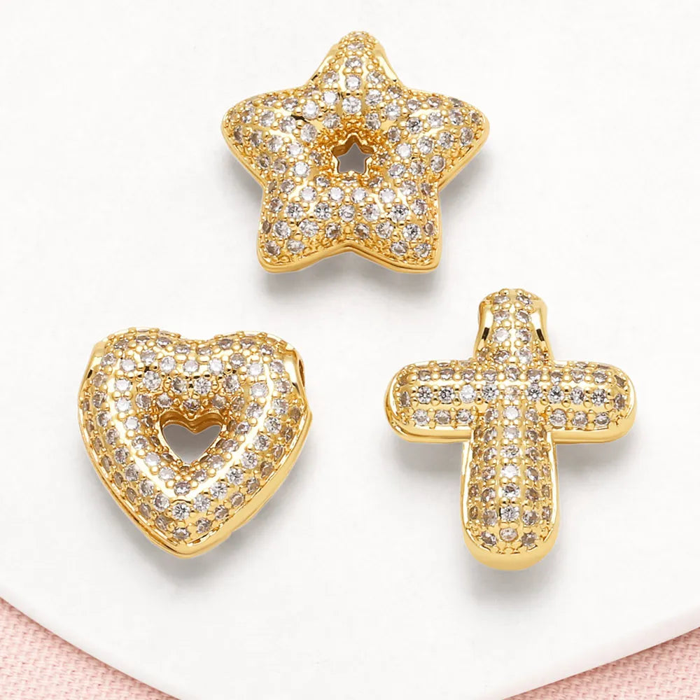 Gold tone crystal heart cross pendant with a star-shaped pendant displayed on a white background