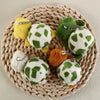 A collection of adorable green and yellow turtle plush keyrings arranged on a woven straw mat.