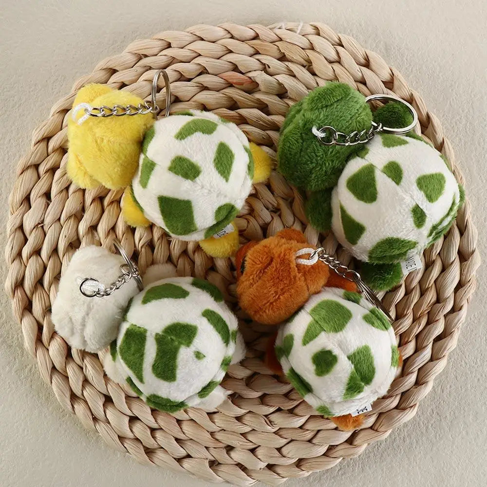 A collection of adorable green and yellow turtle plush keyrings arranged on a woven straw mat.