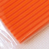 A close-up view of bright orange polymer clay modeling material packaged in clear plastic.