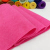 A stack of bright pink felt fabric sheets rolled up for DIY crafts and sewing projects.