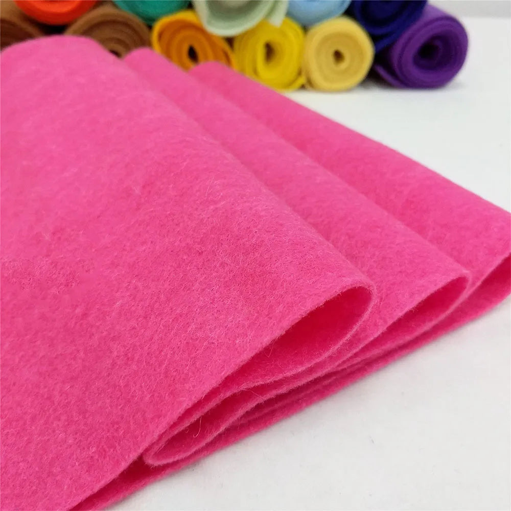 A stack of bright pink felt fabric sheets rolled up for DIY crafts and sewing projects.