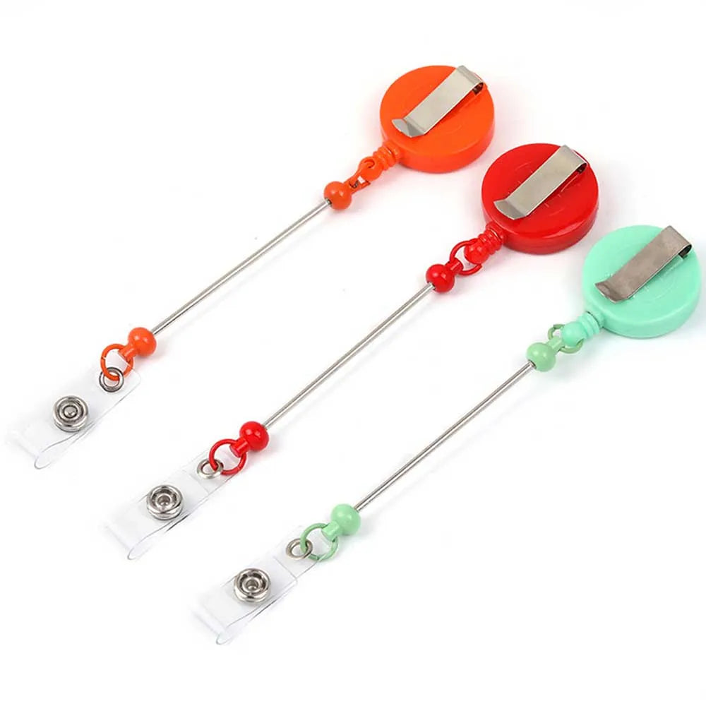 Three beadable badge reels with retractable clips in orange, red, and green colors