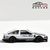 A white and black diecast model of a Toyota AE86 car with racing decals displayed on a white background.