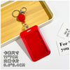 A red retractable ID badge holder with a clip is shown resting on a wooden tray.