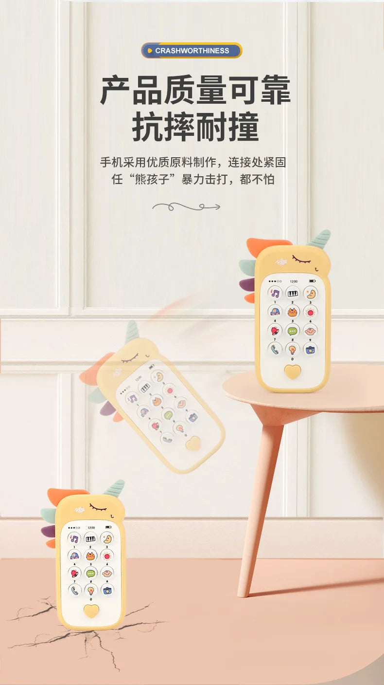 A yellow baby phone toy with colorful buttons is displayed on a wooden table, surrounded by decorative leaves.