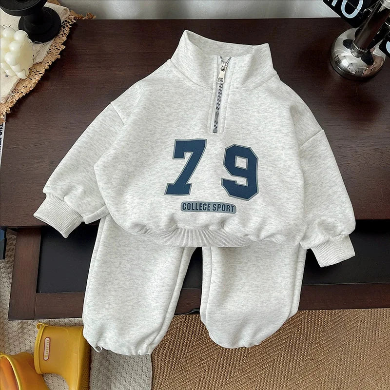 A light gray kids' 2-piece long-sleeve sweater and sweatpants set featuring a large navy blue number 79 on the chest.