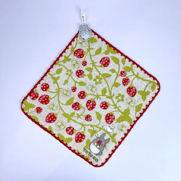 A square felted fabric item featuring a pattern of red strawberries and green leaves on a white background.
