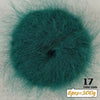 A circular swatch of dark teal long-haired alpaca blend yarn used for knitting.