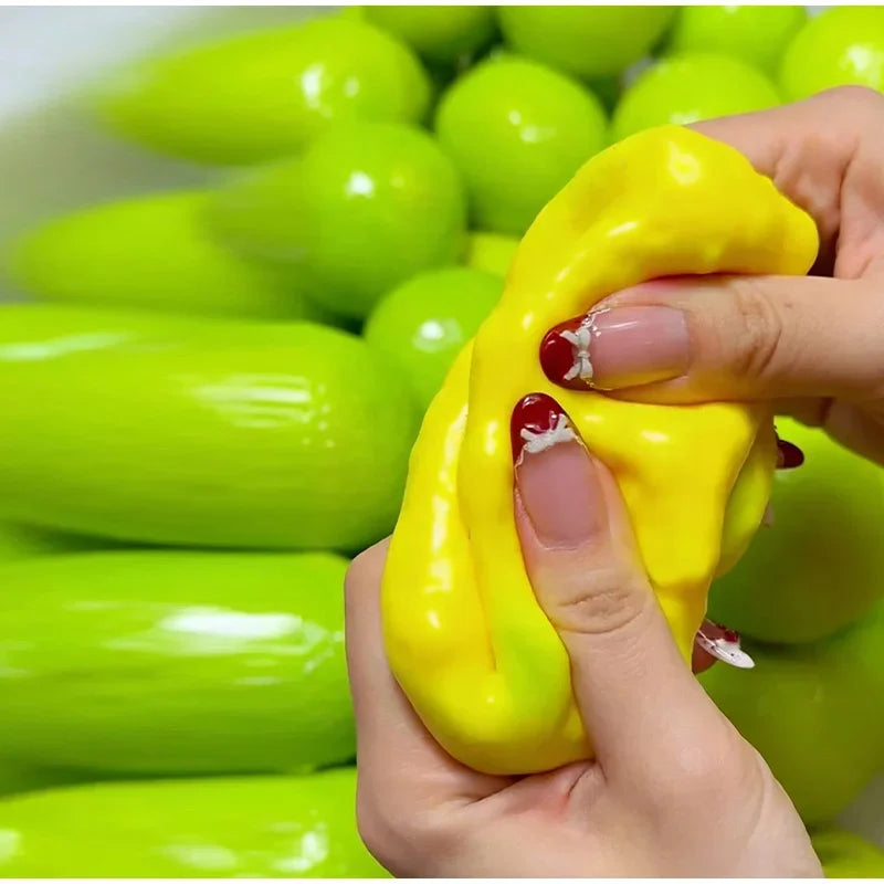 A hand is squeezing a bright yellow, squishy stress ball surrounded by green ones.