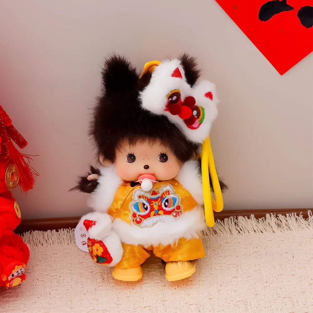 A cute Monchhichi plush keychain with dark hair, white fur accents, and yellow clothing against a light background.
