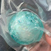 A translucent teal stress ball is visible inside a clear plastic bag.