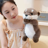 A young woman is holding a brown and white magnetic otter plush toy.